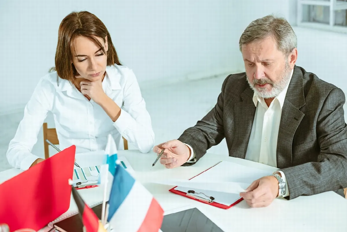 Консультант и клиент обсуждают документы в офисе